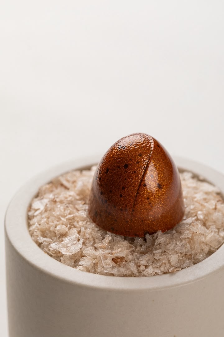Glanzende chocoladebonbon gepresenteerd op kristallen