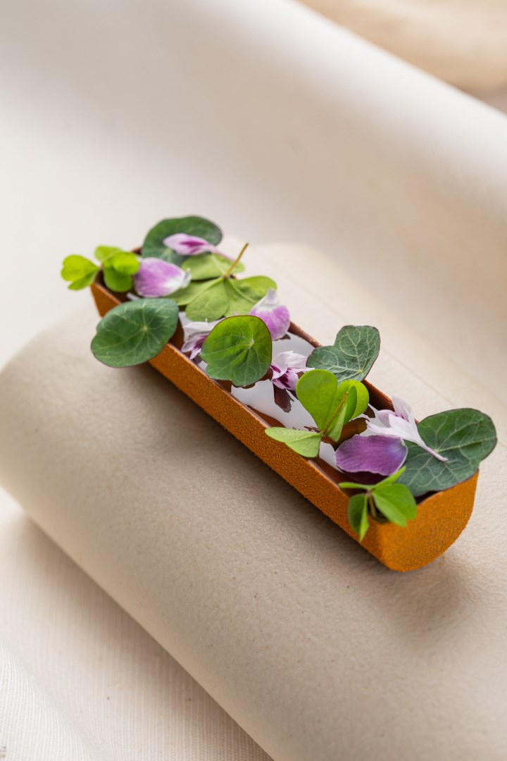 Langwerpige bonbonbar met eetbare bloemen en groene bladeren
