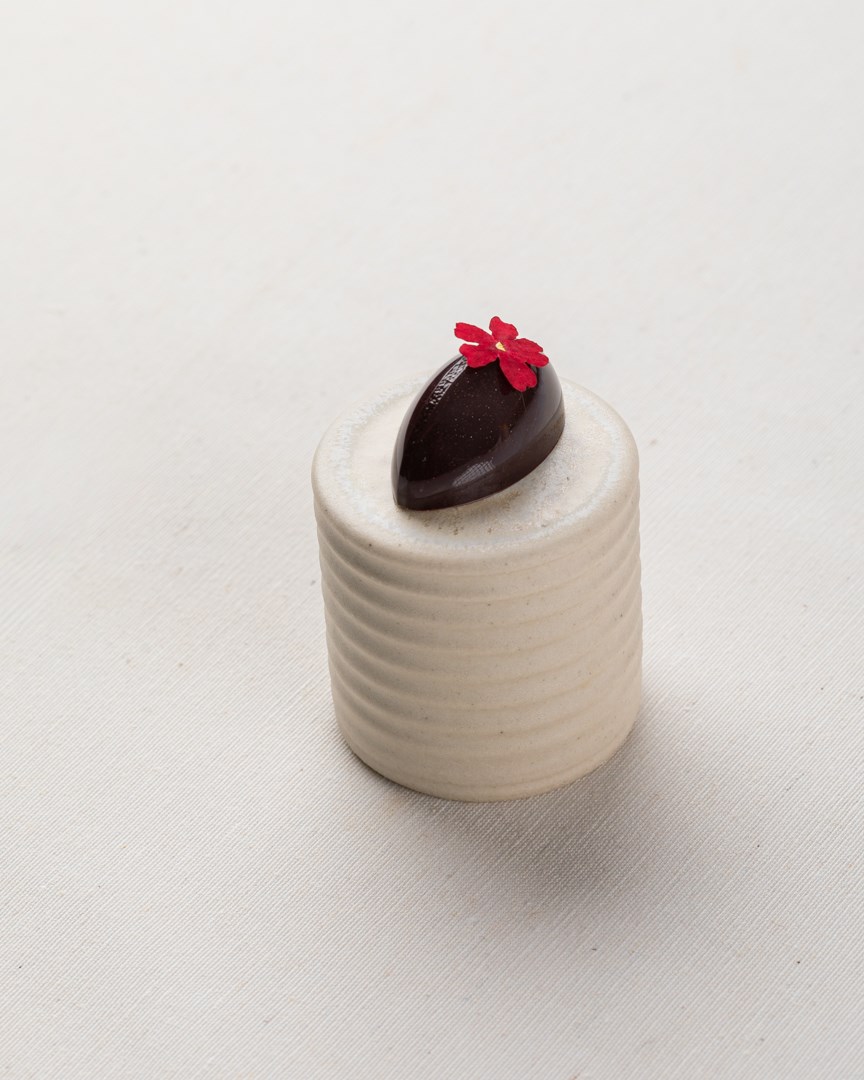 Donkere bonbon met een rode bloem
